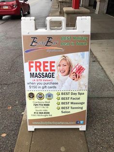 a sign advertising free massage on the sidewalk