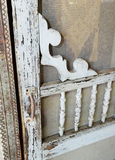 an old white door is open to show the wood carvings on it's sides