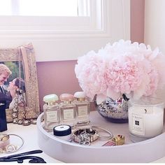 a white table topped with pink flowers next to a window