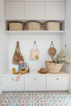 a white shelf with baskets and bags on it