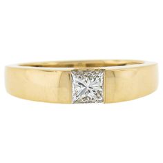 a yellow gold ring with a princess cut diamond