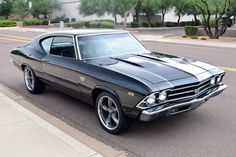 an old muscle car is parked on the side of the road