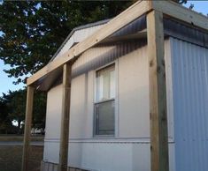 a small white house sitting next to a tree