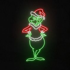 a green and red neon sign with an image of a person wearing a santa hat