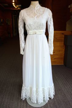 A beautiful 1980's wedding gown made of light weight fabric. Lace bodice, trim and long sleeves. Adorned with a silk bow on the waist and a classic high neck.  Size - 6 to 8 Dress length - 56.5 in Bust - 33.5 in Waist - 25.4 in How it closes - Zipper back White Long Sleeve Victorian Dress For Formal Occasions, Bohemian Belts, Fall Necklaces, 70s Mode, Dresses Business, Formal Fashion Women, Fall Night, White Bridal Shower, Fashion Formal