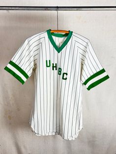 An authentic vintage softball/baseball sports jersey with number on back for Union Hill Baptist Church. flocked iron on letters on front. era : 1960s 70s material : crispy polyester  color : true green, white condition : distressed, visible signs of age and wear as seen in photos including set in stains/patina size : tagged adult large , please compare measurements below actual garment measurements : chest : 21" pit to pit  length : 29" - - - - - - - - - - - - - - - - - - - - - - - - - - - - - - - - - - - - - - - -  INTERNATIONAL SHIPPING AVAILABLE UPON REQUEST Craft Union does NOT accept returns or exchanges, all items are FINAL SALE Please consider the following prior to placing an order : Because measurements are provided, Craft Union does NOT grant refund/exchange requests if an item d Throwback Team-colored Cotton Baseball Jersey, Cotton College Jersey With Three Stripes, Green College Baseball Jersey For Baseball Season, Green Cotton Sports Jersey, Sporty Green Baseball Jersey For Game Day, Green Sporty Baseball Jersey For Game Day, Casual Green Jersey For Game Day, Green Casual Jersey For Game Day, Collegiate Jersey With Baseball Collar In Cotton