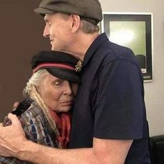 an older man and woman embracing each other