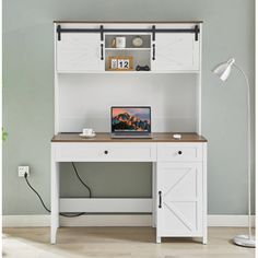 a computer desk with a laptop on it and an open book shelf above the desk