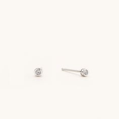 "Sold as a pair.  A jewelry box staple. These genuine sterling silver bezel stud earrings are a simple must-have, featuring the brilliant AAA grade cubic zirconia this contemporary design bezel set is perfect for your everyday life. The perfect accessory to go with any outfit, these sparkling CZ stones will glimmer on every side in all your photos. The blingy tiny studs are beautiful and affordable, you can buy them with confidence knowing that you can wear them for any occasion. It is great for daily wear such as jeans & t-shirts to dressy outfits like business suits and evening gowns. This retro-glam stud earring will be classier if you pair them with a cool tee and denim jacket together. Selection from 2mm, 3mm, and 4mm for multi-pierced women, men, or children, and for those who have m Minimalist White Gold Earrings With Bezel Setting, Silver Earrings With Single Diamond For Gift, Silver Minimalist Birthstone Earrings, Minimalist White Gold Birthstone Earrings, Minimalist Bezel Set Earrings, Minimalist Round Earrings With Bezel Setting, Minimalist Round Bezel Set Earrings, Minimalist Silver Earrings With Bezel Setting, Minimalist Everyday Earrings With Bezel Setting