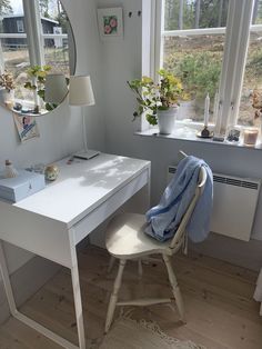 a white desk with a mirror and chair in front of it next to a window