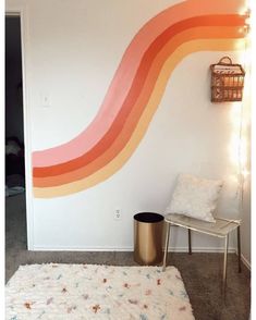 a room with a white rug and a rainbow painted on the wall next to a chair