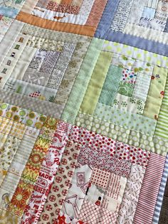 a close up of a patchwork quilt with many different colors and patterns on it