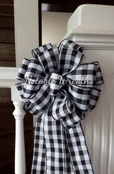 a black and white checkered bow hanging on the side of a stair rail with an inscription