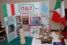 there is a display with pictures and flags on the table in front of it that says italy