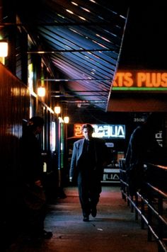 a man is walking down the street at night