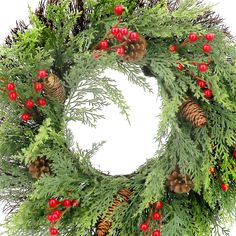 a christmas wreath with pine cones and red berries