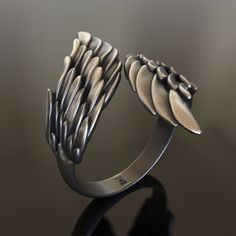 Introducing our enchanting handcrafted 925 Sterling Silver Wings Ring, a captivating accessory that symbolizes freedom, spirituality, and the ethereal world of angels. This unique ring features an intricate design of delicate wings, crafted from high-quality, solid 925 sterling silver to ensure durability and longevity. Our Wings Ring is a unisex accessory, making it a perfect choice for both men and women who appreciate the allure of angelic symbols and the idea of soaring free. Its detailed de Symbolic Sterling Silver Jewelry With Unique Design, Spiritual Winged Sterling Silver Jewelry, Sterling Silver Winged Rings In Silver, Artistic Sterling Silver Jewelry With Unique Design, Promise Sterling Silver Jewelry With Oxidized Finish, Hand-cast Sterling Silver Promise Jewelry, Angelic Symbols, Wings Ring, Viking Ring