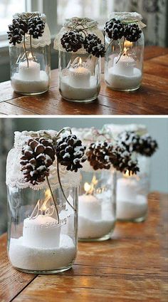 pine cones and candles are in mason jars with snow on the top, and one is lit