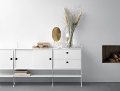 a white sideboard with two drawers and a mirror on the wall next to it