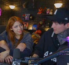 a man and woman sitting next to each other in front of microphones