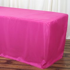 a bright pink table cover on a wooden floor