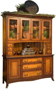 an old fashioned china cabinet with glass doors and moss growing on it's top