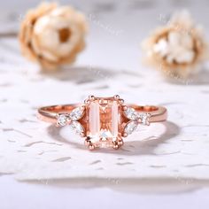 an image of a pink diamond ring on a lace doily with flowers in the background