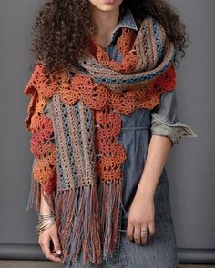 a woman wearing a crocheted shawl and denim shirt