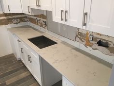 an unfinished kitchen counter top with white cabinets