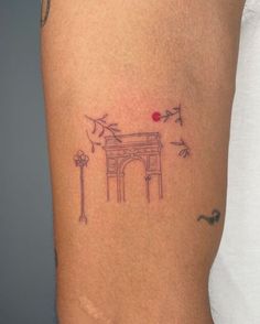 a woman's thigh with a small tattoo on the side of her leg that has an arch in it