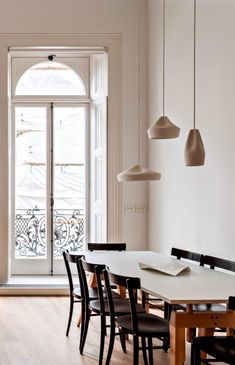 a dining room table and chairs with an open door