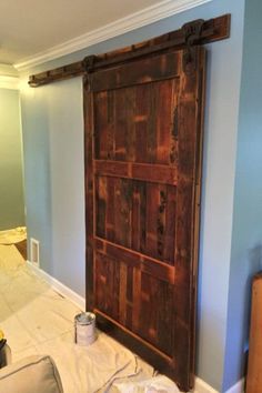 the interior of a house being remodeled with blue walls and white trim, including a sliding barn door