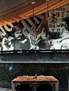 a restaurant with a large mural on the wall and tables in front of it,