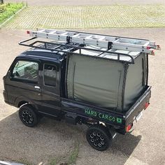 a black truck parked on top of a parking lot next to a grass covered field