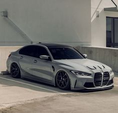 a silver car parked in front of a white building next to a parking space with stairs