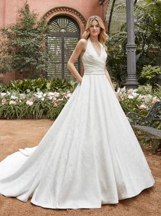 a woman in a white wedding dress posing for the camera