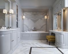 a white bathroom with marble floors and walls