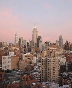 the city skyline is shown at sunset with tall buildings in the foreground and skyscrapers in the background