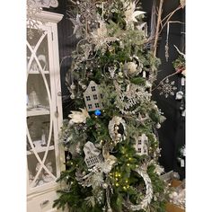 a white christmas tree with silver ornaments and lights