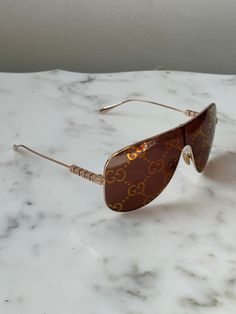 Brand new Gucci GG1436S 003 Rose Gold Metal Sunglasses. Rose gold metal mask shape. 100% UVA and UVB protection. Brown with mirror GG logo lens. Lenses do not impede vision!Made in Italy.Comes with Gucci jewel-toned velvet hard case, satin pouch, cleaning cloth, and cards.100% authentic and unworn. Mask Sunglasses, Metal Mask, Satin Pouch, Mask Shapes, Gg Logo, Men's Eyeglasses, Metal Sunglasses, Rose Gold Metal, Jewel Tones