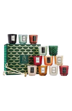 an assortment of candles in front of a green box