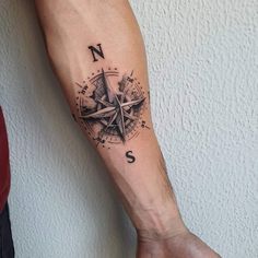 a man with a compass tattoo on his arm