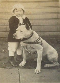 an old black and white photo of a child with a dog