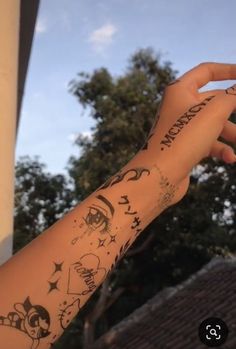 a person's arm with tattoos on it and trees in the backgroud