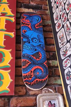 a skateboard sitting on top of a brick wall next to other skateboards and stickers