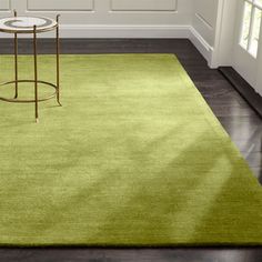 a green rug in a room with white walls