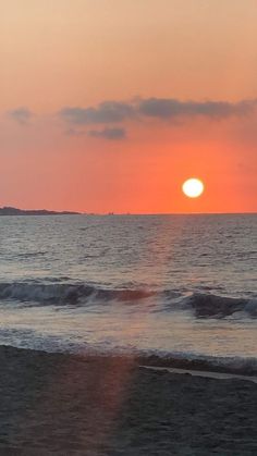 the sun is setting over the ocean with waves