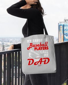 a woman holding a tote bag that says, my favorite baseball players call me dad