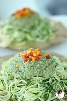 two plates filled with pasta and veggies on top of each other