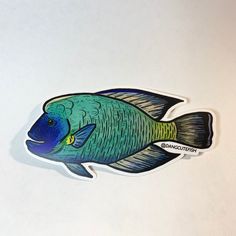 a blue fish sticker sitting on top of a white table